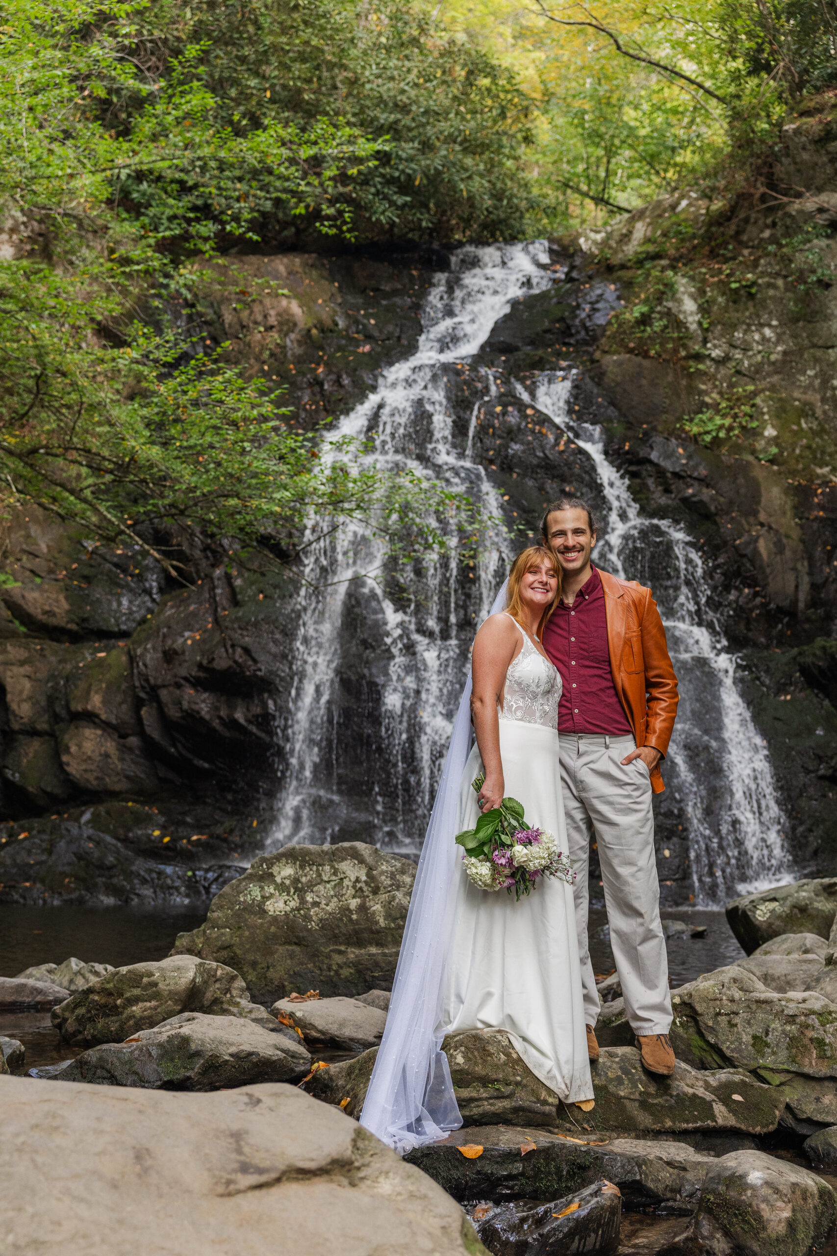 couple pose in front of the Appalachian waterfall
