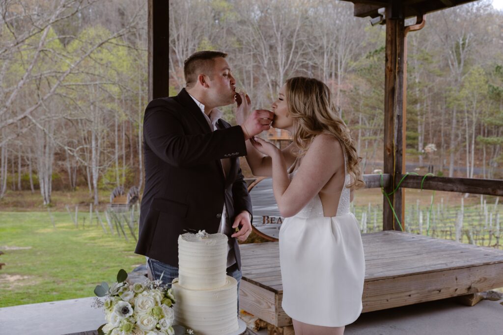 A bride and groom feed each other cake incorporating tradition into their elopement.