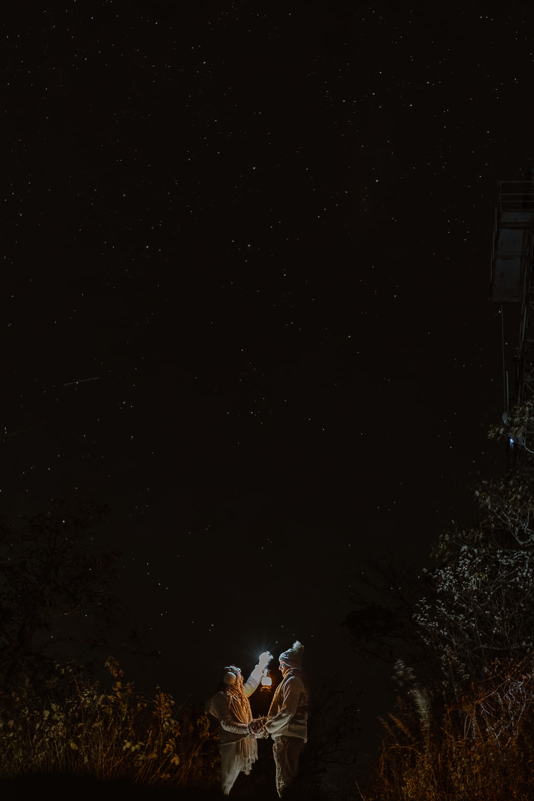 couple look out at the night sky with a lantern during their Asheville elopement