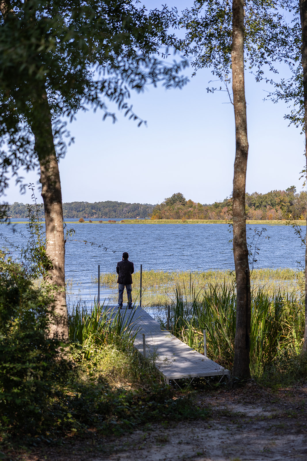 groom eagerly awaits his soon to be wife at the end of the dock