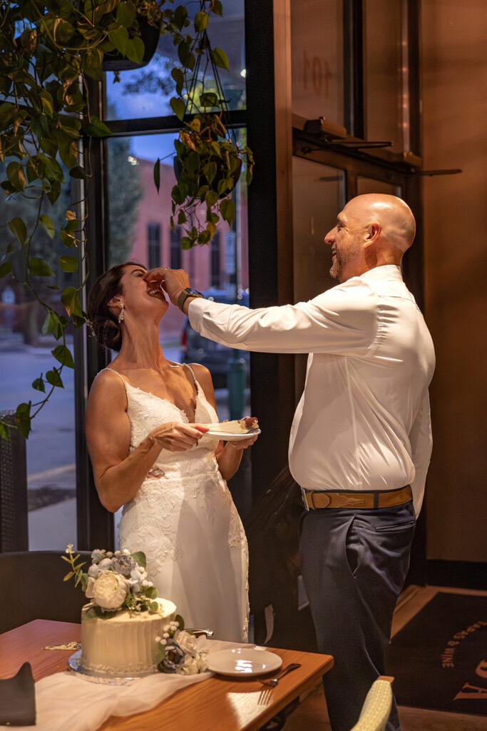 bride and groom feed each other cake as they celebrate their elopement day!