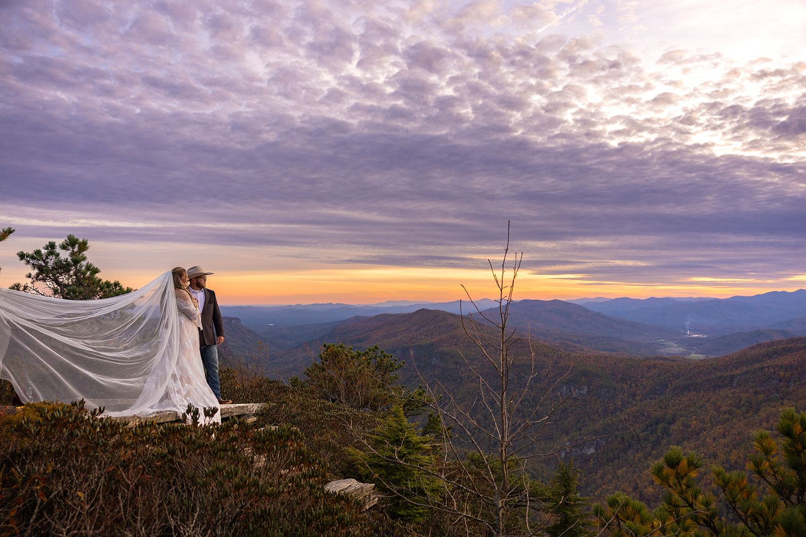 stunning couple look out as the sunsets over their elopement in the mountains