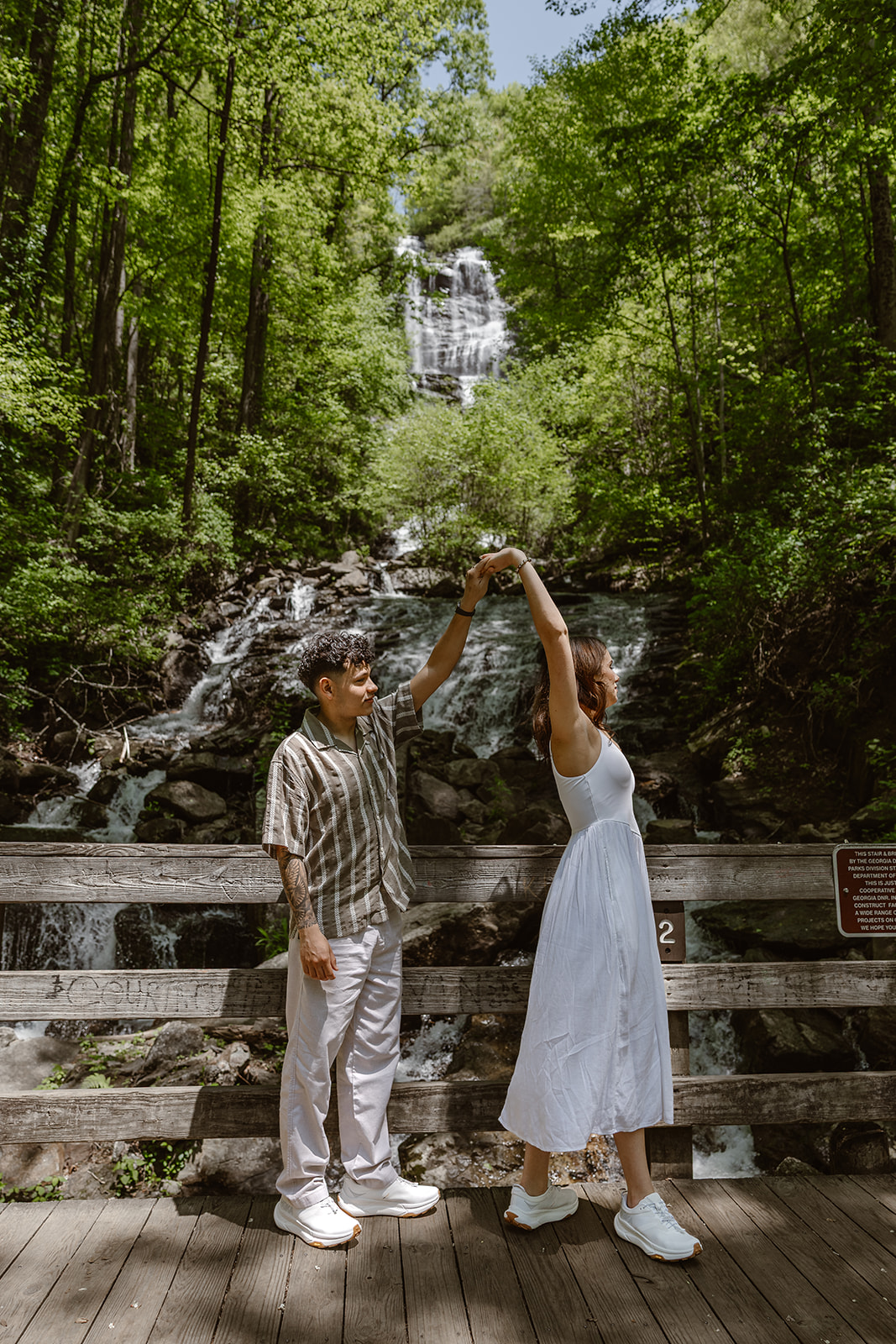 couple dance in front of the waterfall before their waterfall elopement