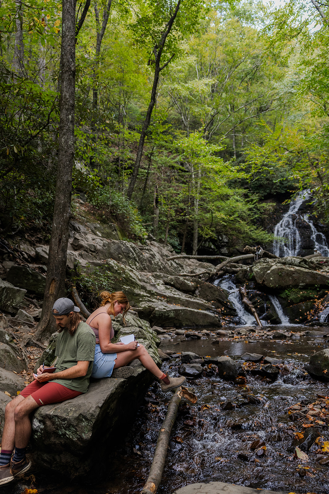 couple read their hand written vows sitting on a rock