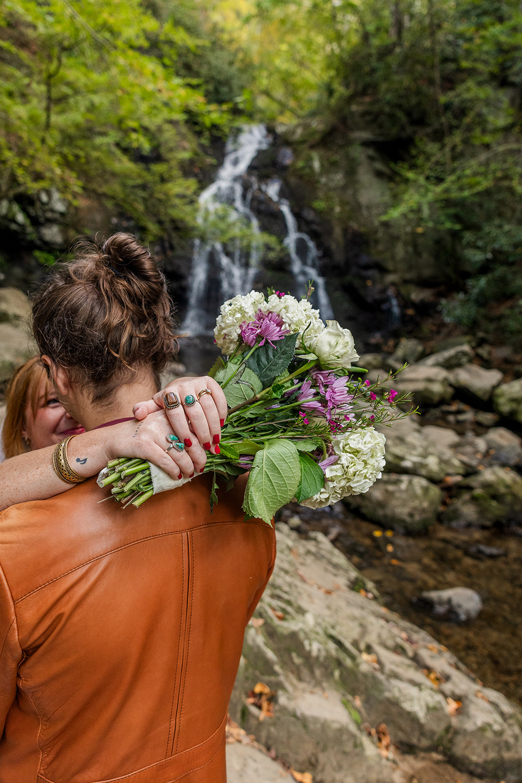 couple share an hug and romantic moment during their waterfall elopement