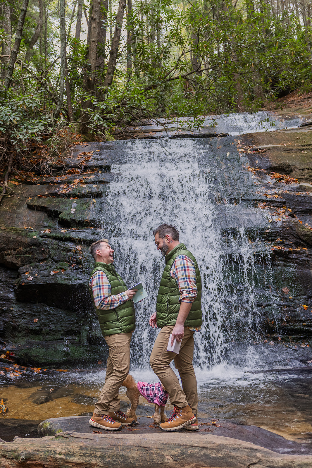 couple share an intimate moment with themselves and their dog during their waterfall elopement