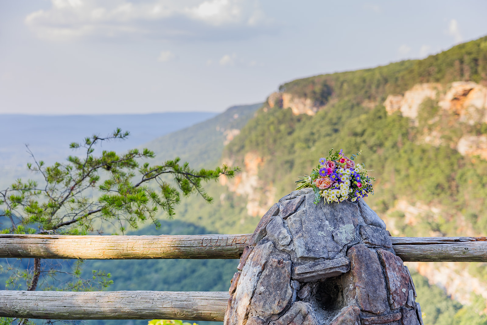 brides bouquet lies on top of the fence post